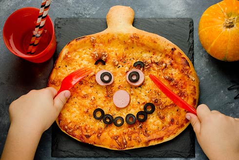 Eine Pizza mit Gemüse-Gesicht kommt bei den Kleinen gut an