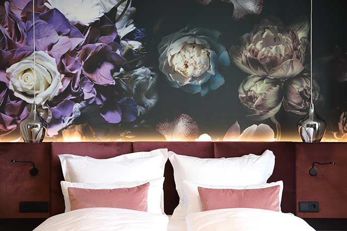 Doppelbett im Boutiquehotel mit floraler Tapete