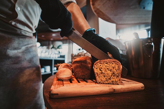 Koch schneidet Brot